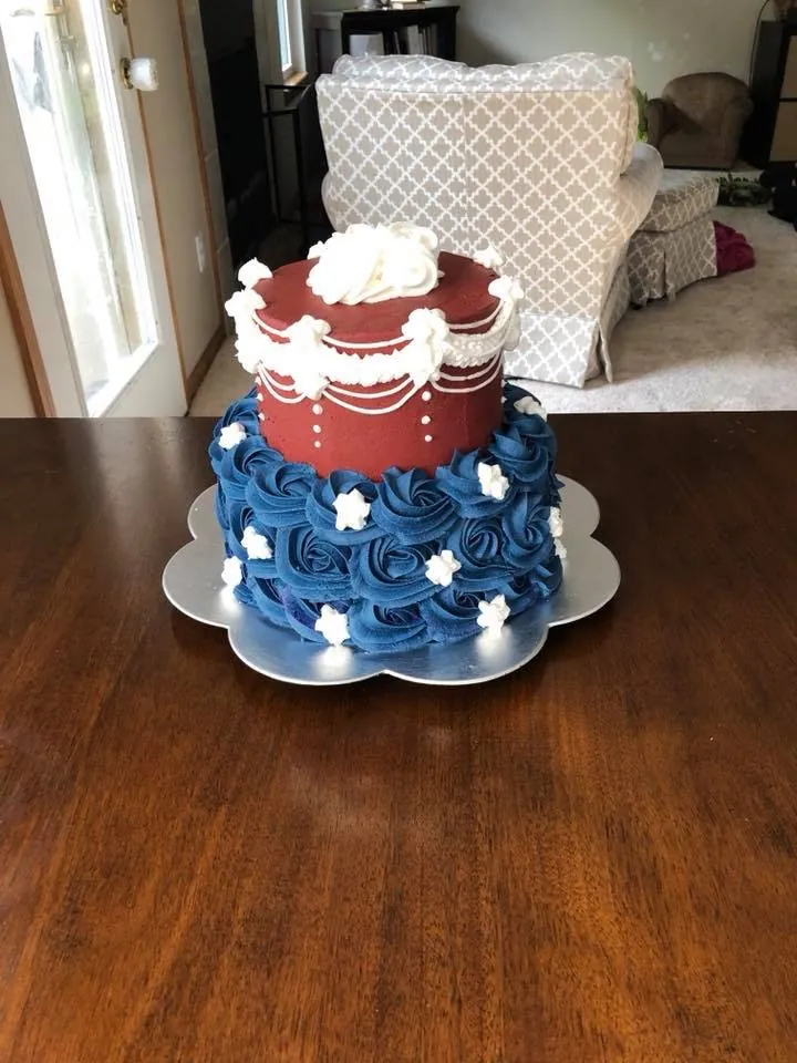 Red, white, and blue celebration cake with piped rosettes and textured buttercream